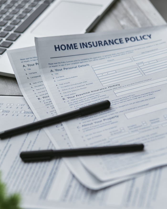 Close-up of home insurance documents with a laptop for financial planning.