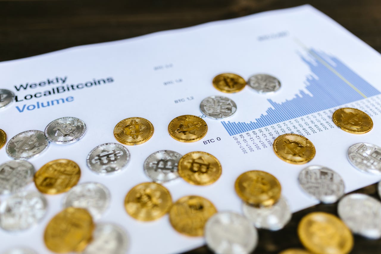 Gold and silver Bitcoin coins placed on a graph showing LocalBitcoins trading volume analysis, symbolizing cryptocurrency market trends.